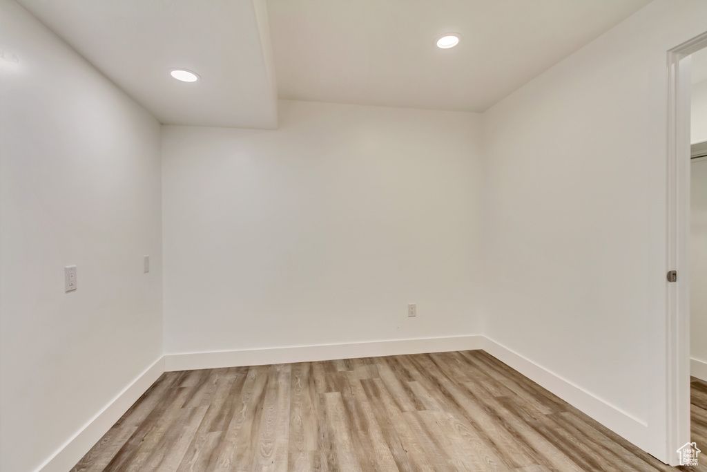 Spare room with light wood-style floors, baseboards, and recessed lighting