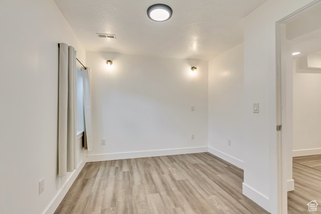 Unfurnished room featuring light wood-style flooring and baseboards