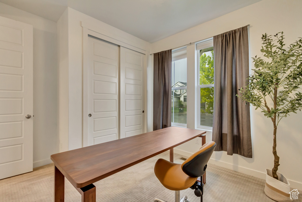 Office with light colored carpet and baseboards