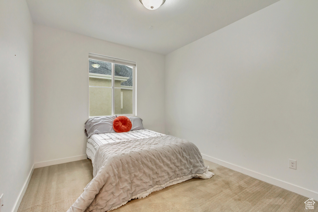 Bedroom with baseboards and light carpet
