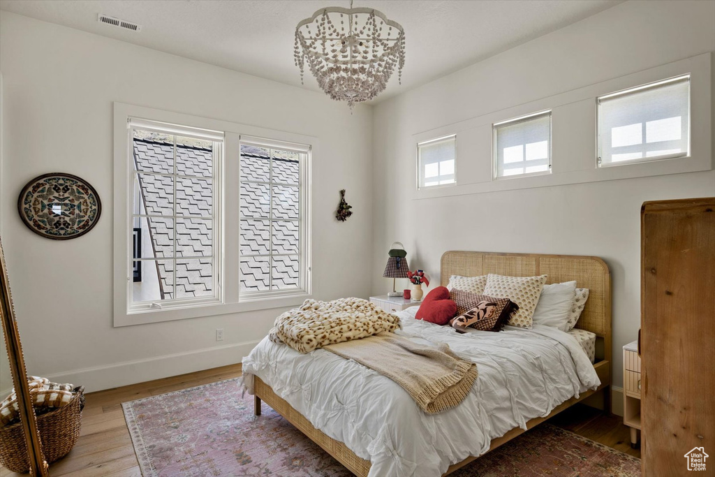 Bedroom featuring baseboards, wood finished floors, and a chandelier
