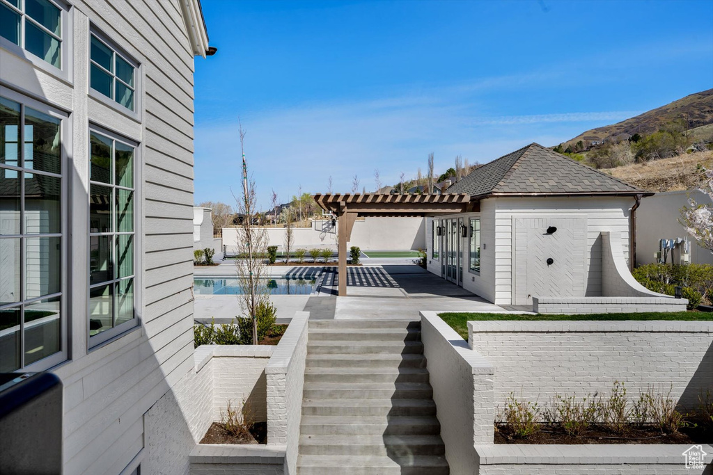 Wooden deck with a pergola, a patio area, and stairway
