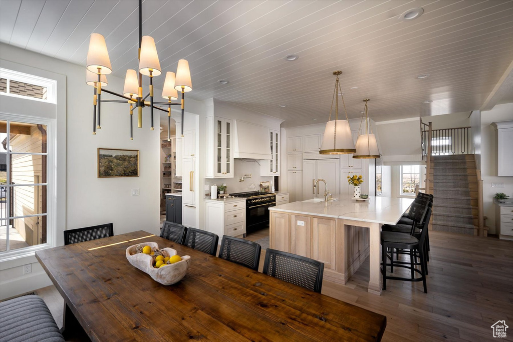 Dining area with wood finished floors, a chandelier, stairs, and wooden ceiling