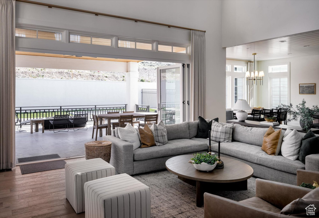Living area featuring a chandelier, a towering ceiling, and wood finished floors