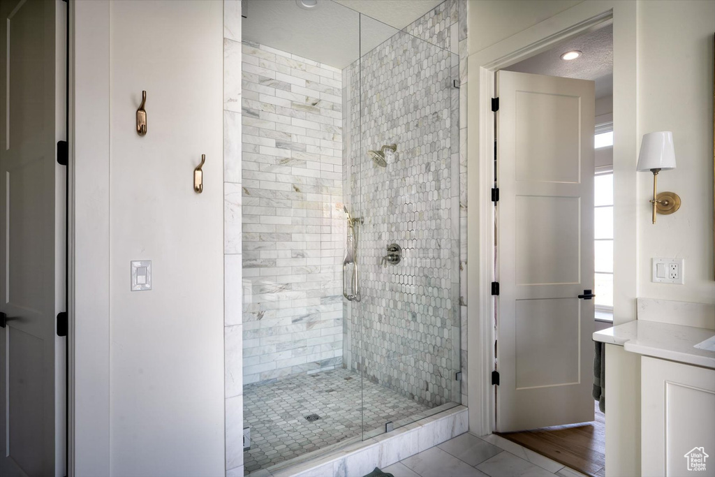 Full bath with a stall shower, vanity, and recessed lighting