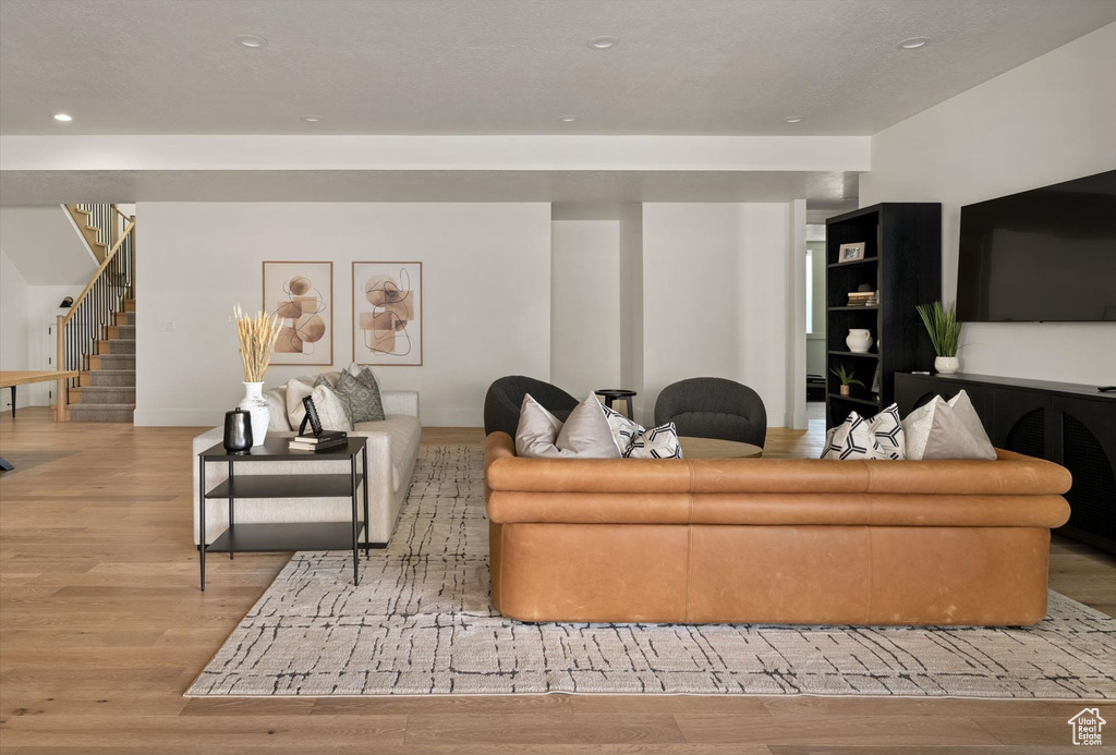 Living area featuring wood finished floors, stairway, recessed lighting, and baseboards