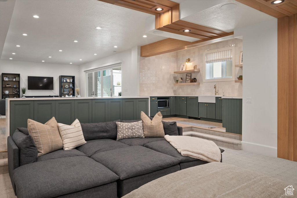 Living area with recessed lighting, wet bar, and light carpet
