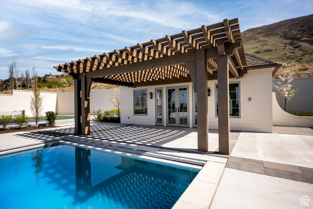 View of pool with french doors, a patio, a pergola, and fence