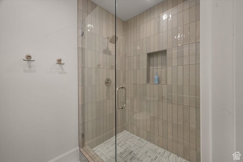 Bathroom featuring a shower stall and baseboards