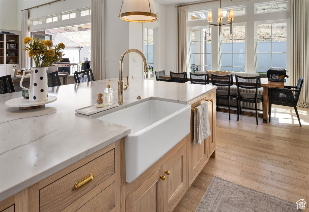 Kitchen with a sink, light wood finished floors, and healthy amount of natural light