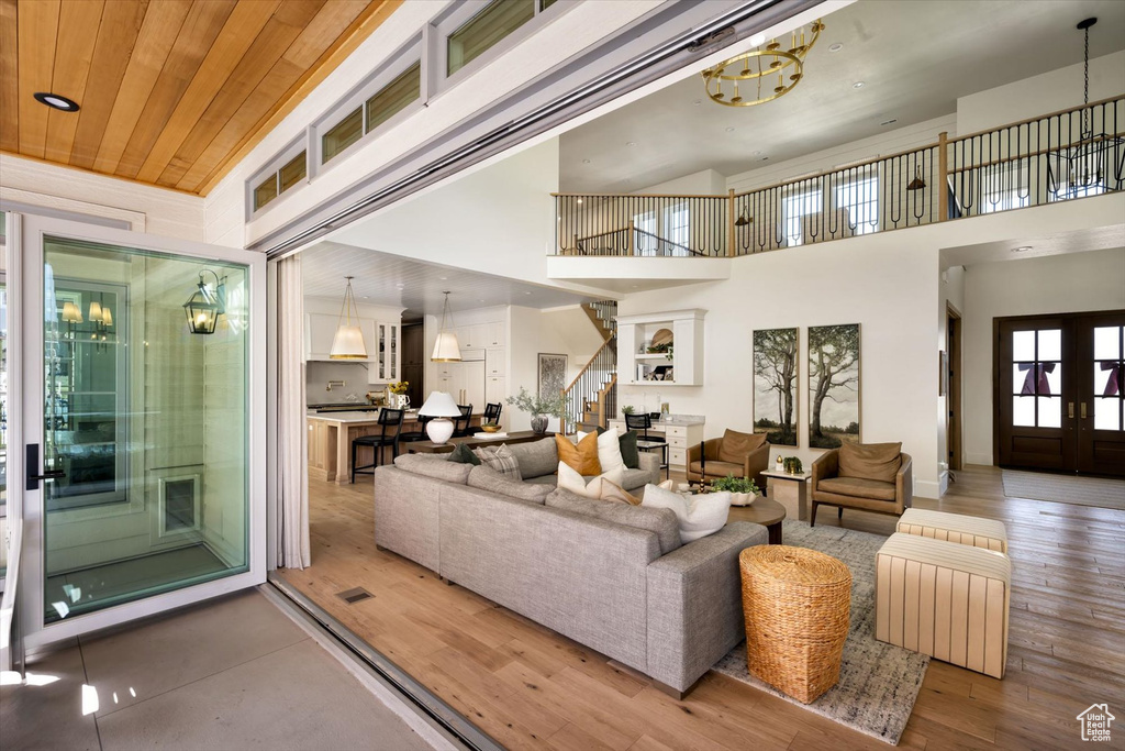 Living area with stairs, wood finished floors, a high ceiling, and recessed lighting