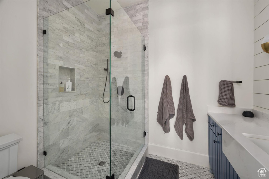 Bathroom featuring a stall shower, toilet, and vanity