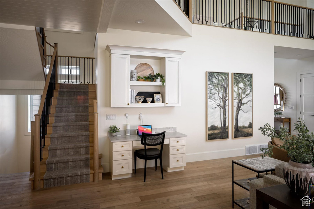 Living room with stairway, light wood-type flooring, and baseboards
