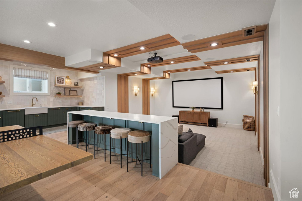 Cinema with a sink, light wood-style flooring, recessed lighting, and baseboards