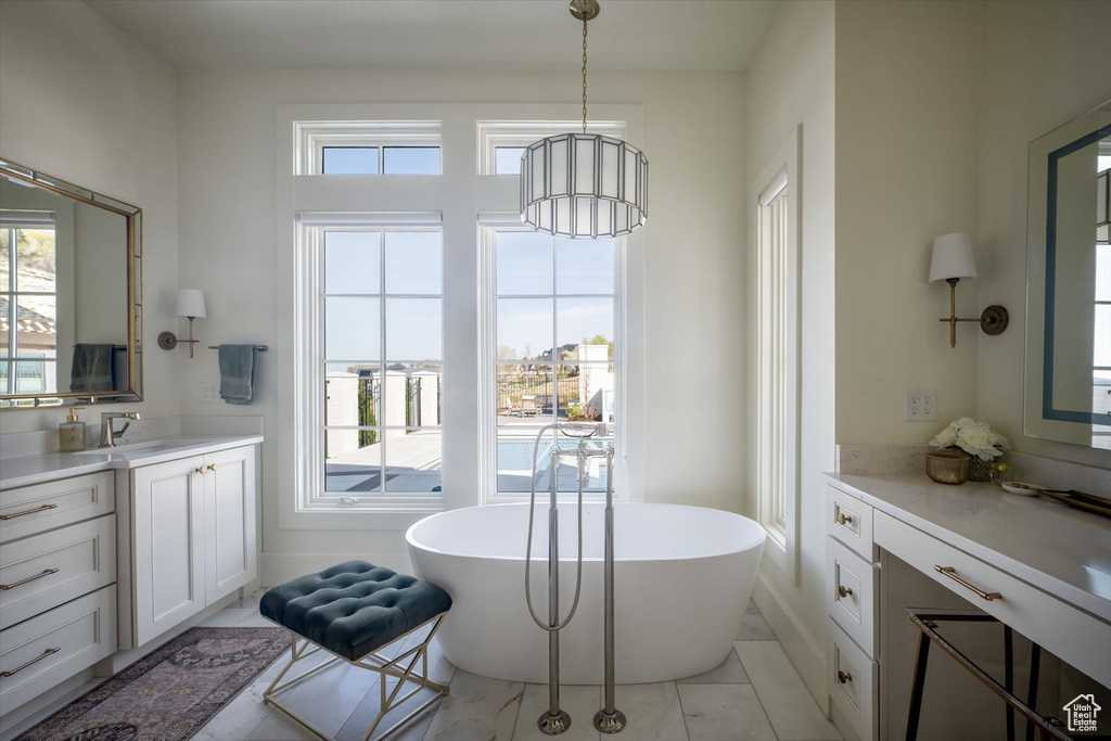 Full bathroom with healthy amount of natural light, vanity, and a soaking tub