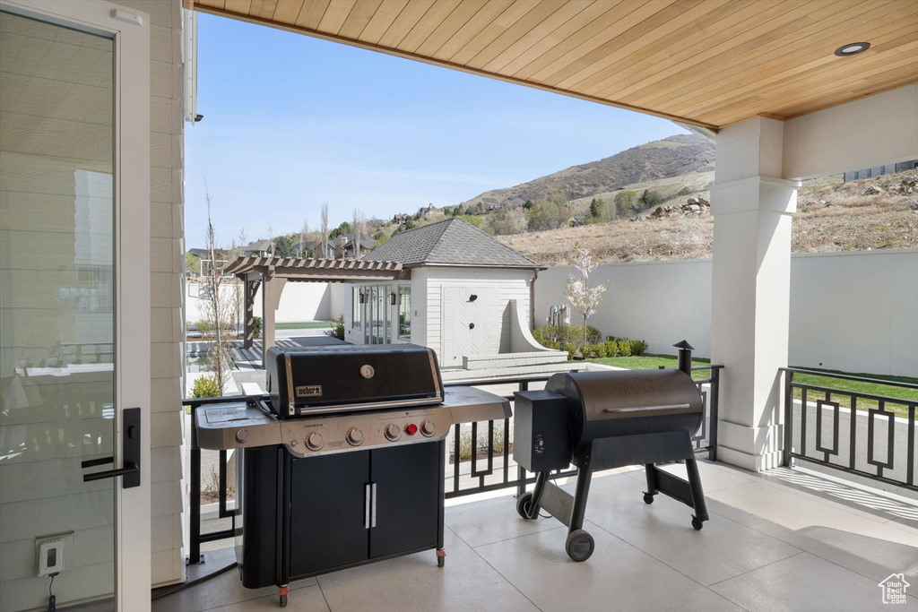 View of patio with a mountain view, a pergola, and fence