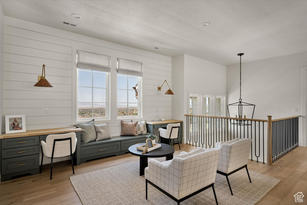 Living room with healthy amount of natural light, light wood-type flooring, and a textured ceiling
