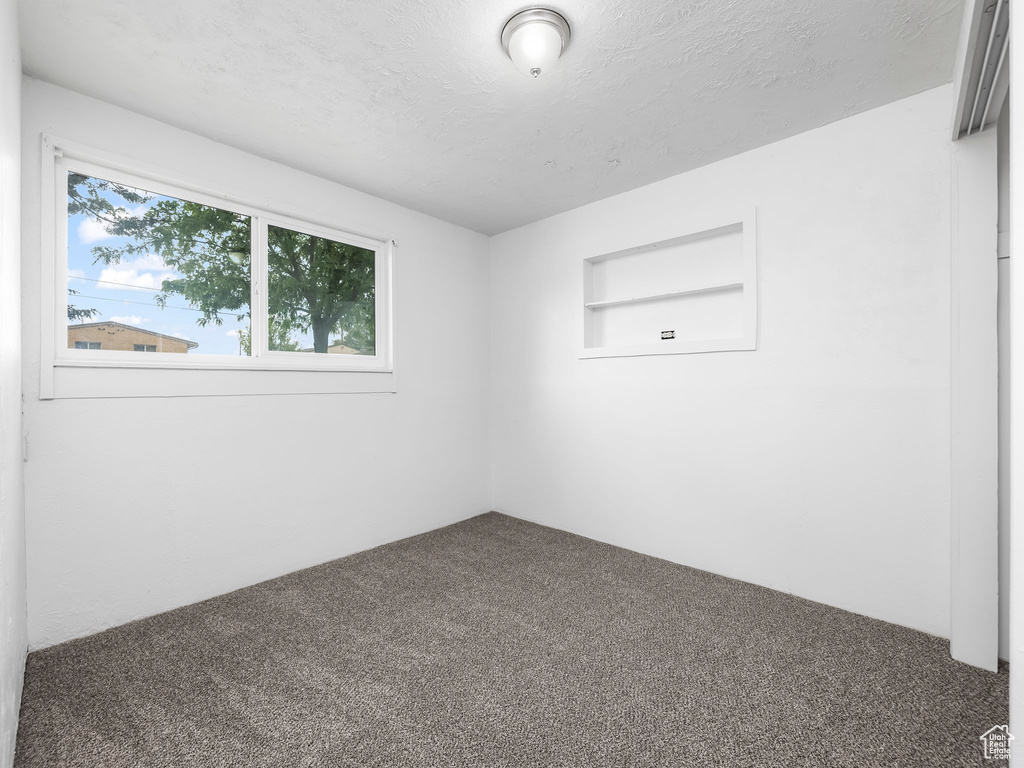 Carpeted spare room with a textured ceiling