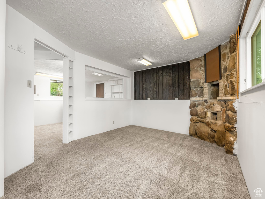 Below grade area with carpet and a textured ceiling