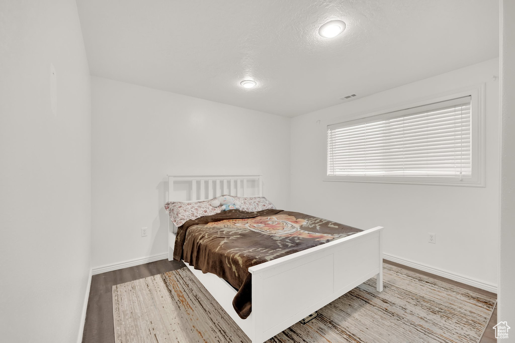 Bedroom featuring wood finished floors and baseboards