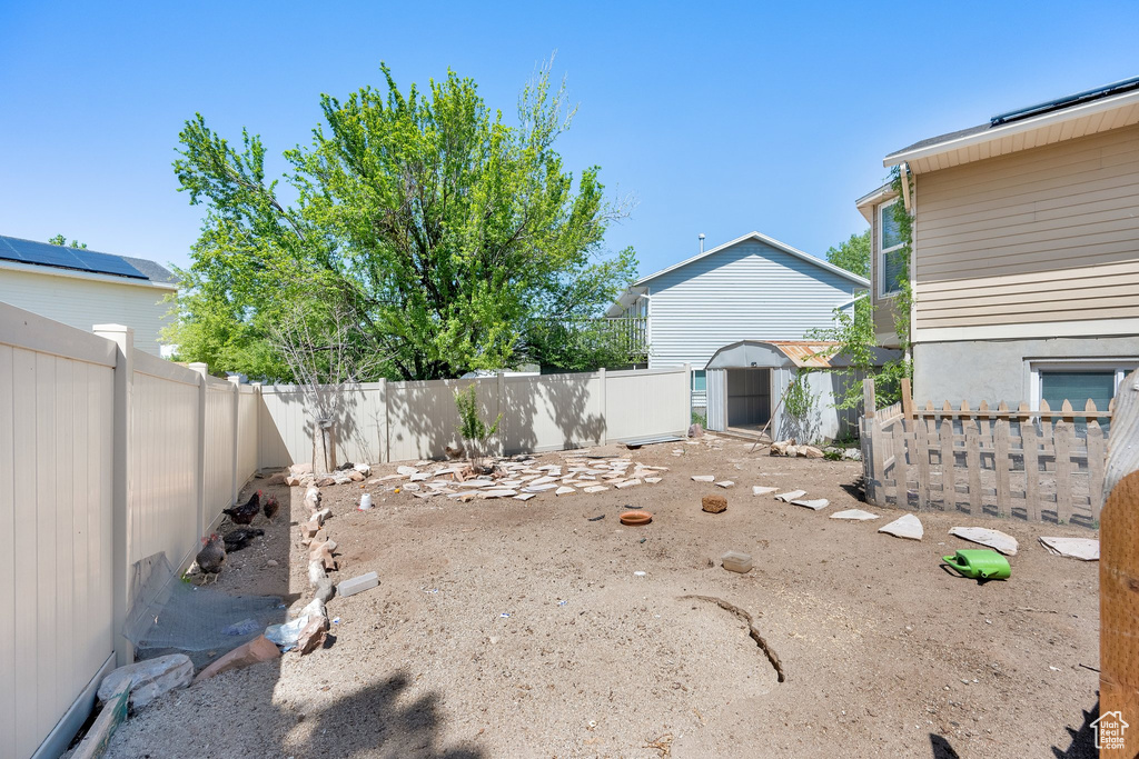 Fenced backyard with a storage shed and an outdoor structure