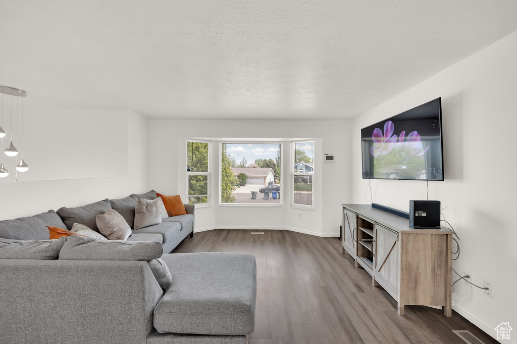Living area featuring dark wood-type flooring and baseboards