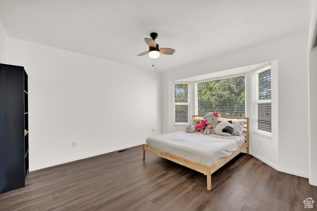 Bedroom featuring wood finished floors, baseboards, and ceiling fan