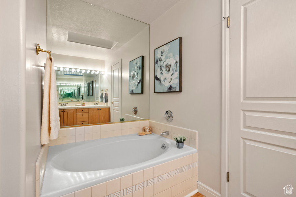 Bathroom featuring a garden tub and vanity