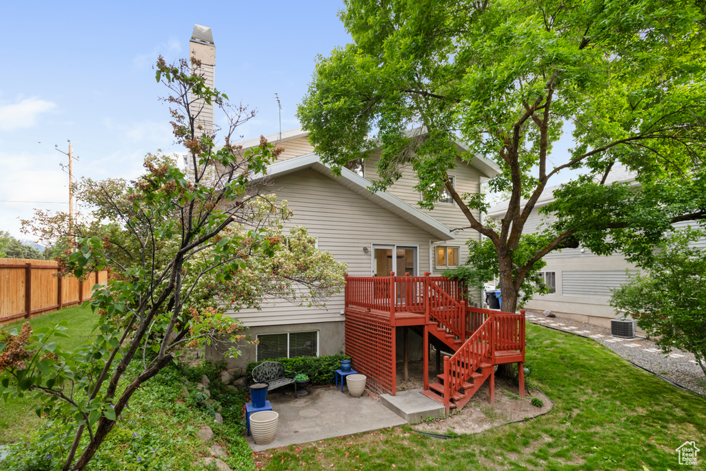 Back of property with stairway, a patio, central AC unit, and a deck