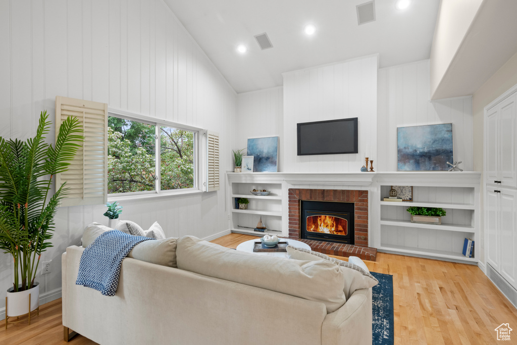 Living area featuring a brick fireplace, wood finished floors, recessed lighting, and baseboards