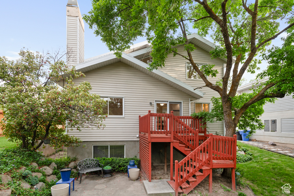 Back of house with stairway, a chimney, and a patio area