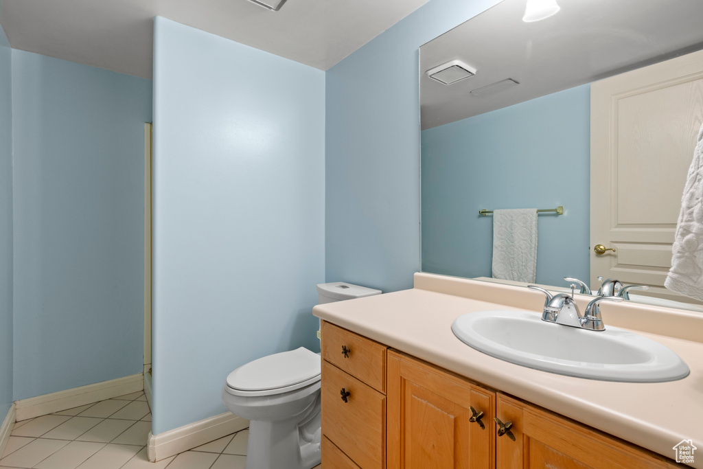 Full bathroom featuring tile patterned floors, toilet, vanity, baseboards, and a shower