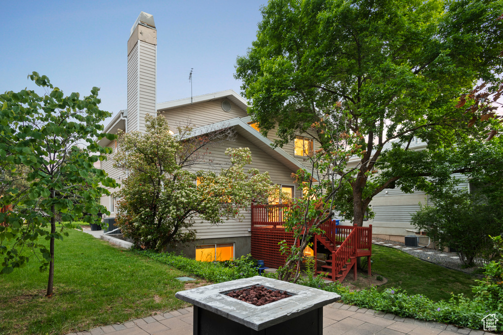 View of patio / terrace with an outdoor fire pit, stairway, a deck, and central AC unit