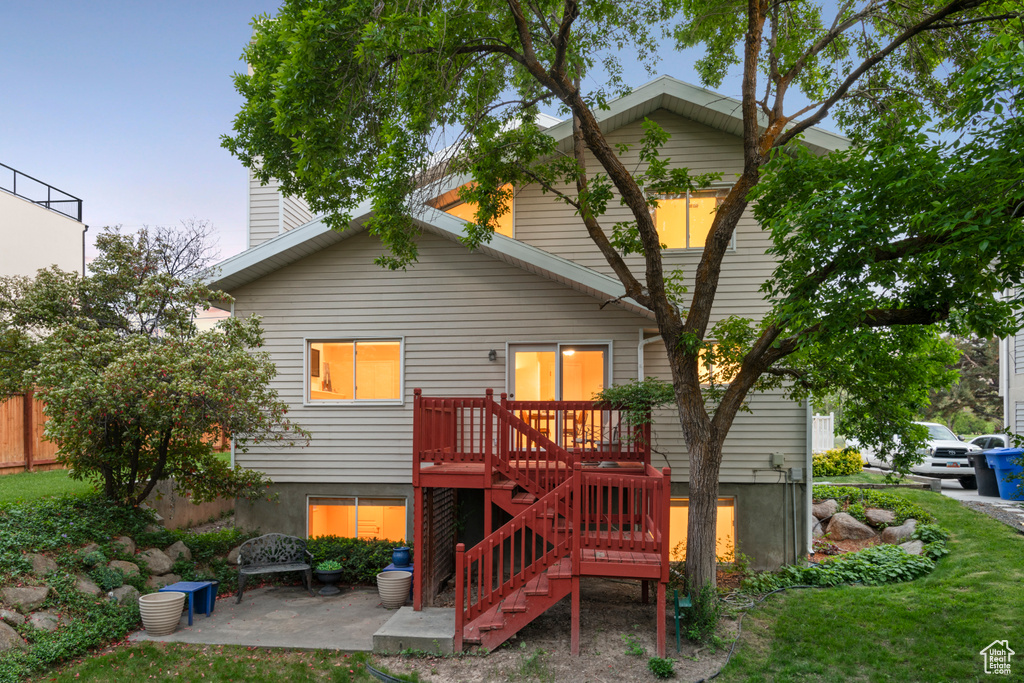 Back of house with stairs, a patio area, and a chimney