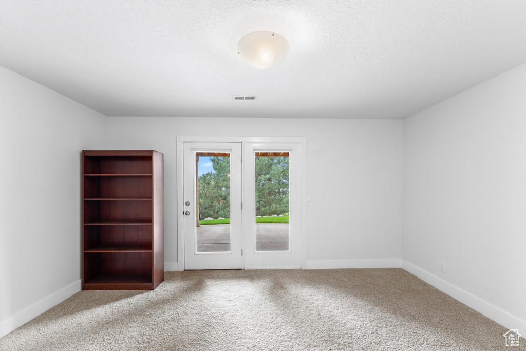 Carpeted spare room with baseboards and a textured ceiling