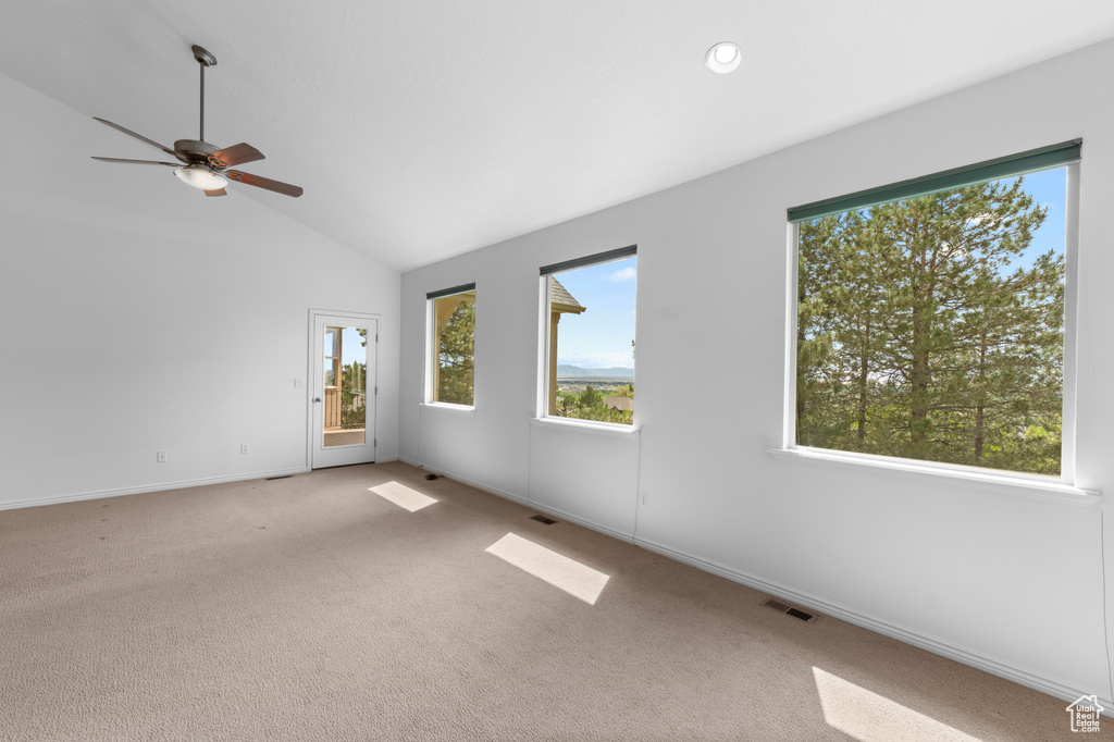 Spare room featuring light carpet, ceiling fan, lofted ceiling, baseboards, and recessed lighting