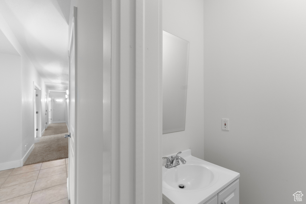 Bathroom featuring vanity, tile patterned floors, and baseboards