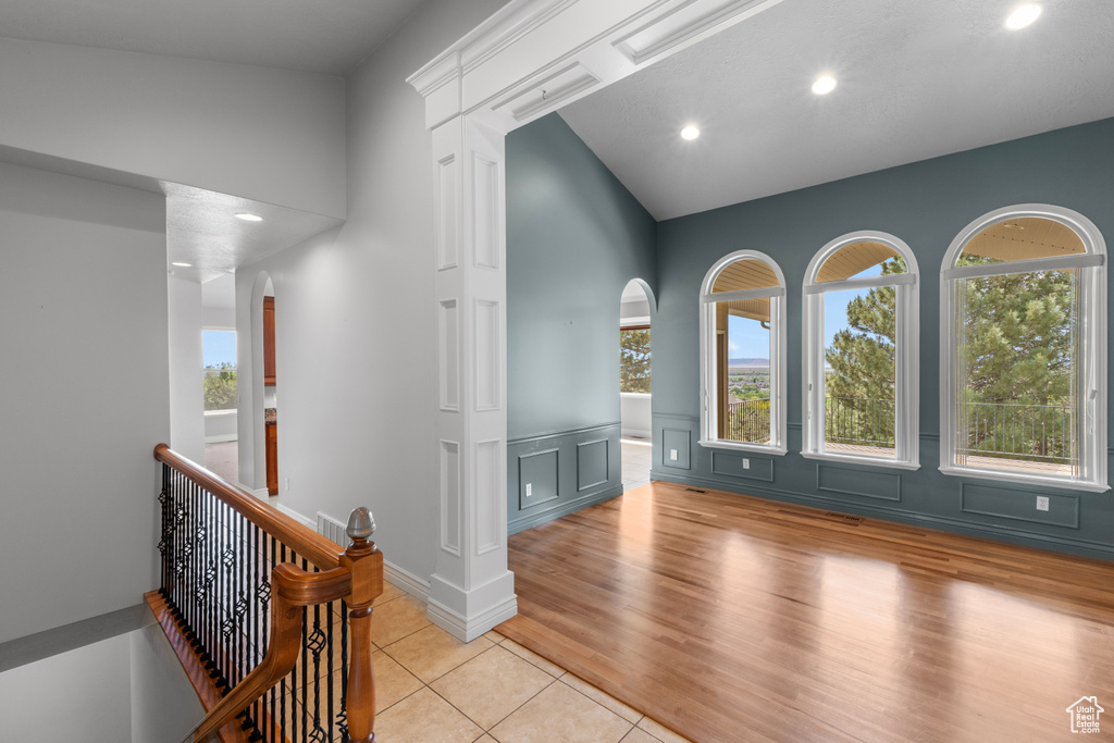 Interior space featuring arched walkways, plenty of natural light, light tile patterned flooring, recessed lighting, and vaulted ceiling