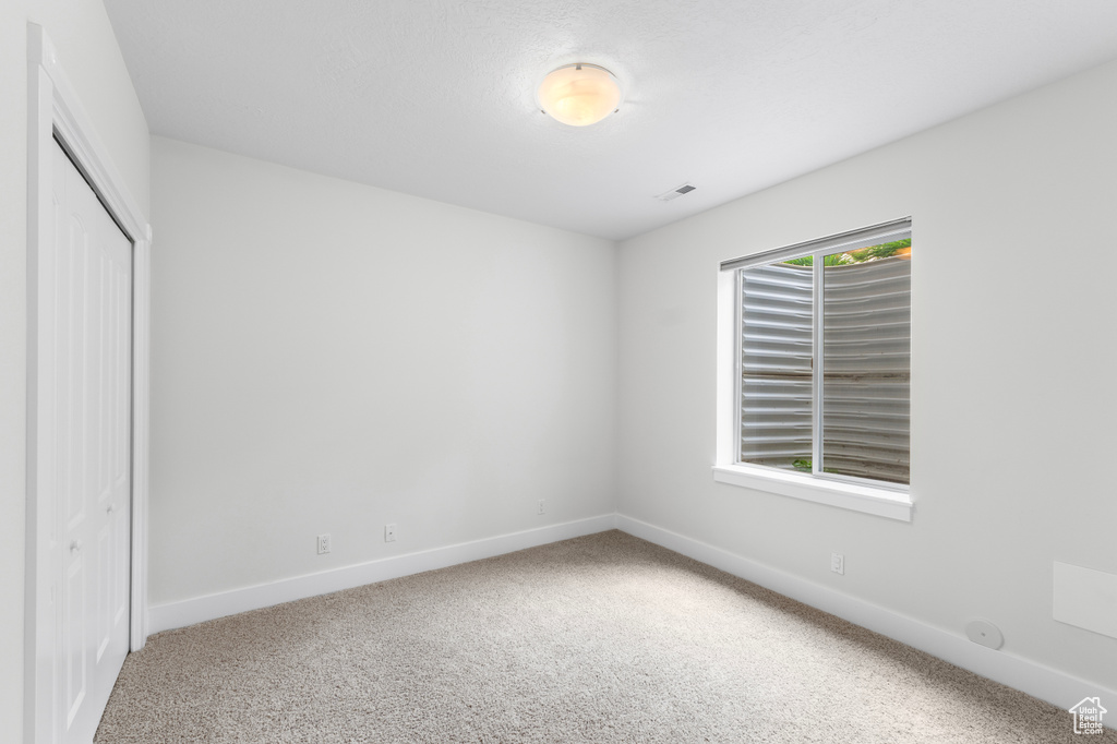 Unfurnished bedroom featuring baseboards, carpet, and a closet