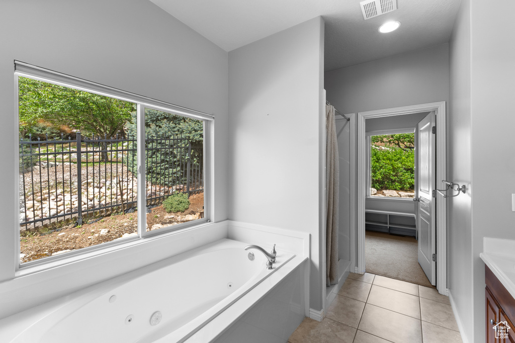 Bathroom with a shower stall, tile patterned floors, a jetted tub, vanity, and baseboards