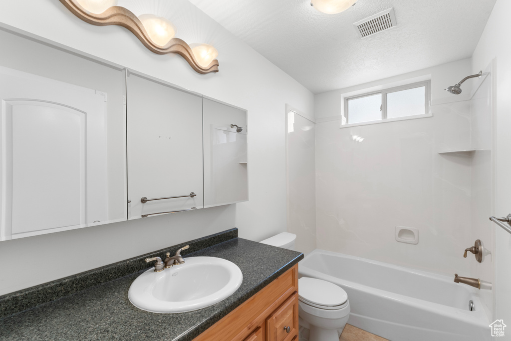 Full bathroom featuring toilet, shower / bathtub combination, and vanity