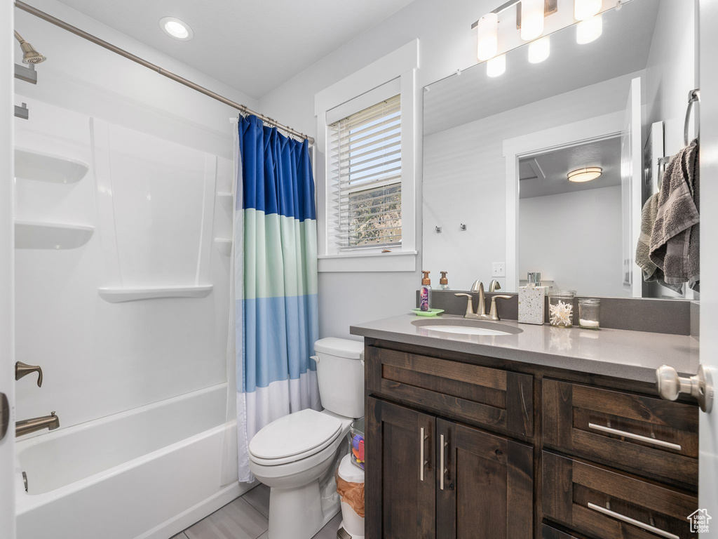 Full bathroom featuring toilet, vanity, and shower / tub combo