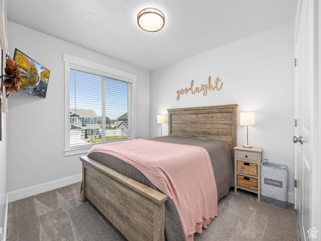Bedroom featuring carpet floors and baseboards
