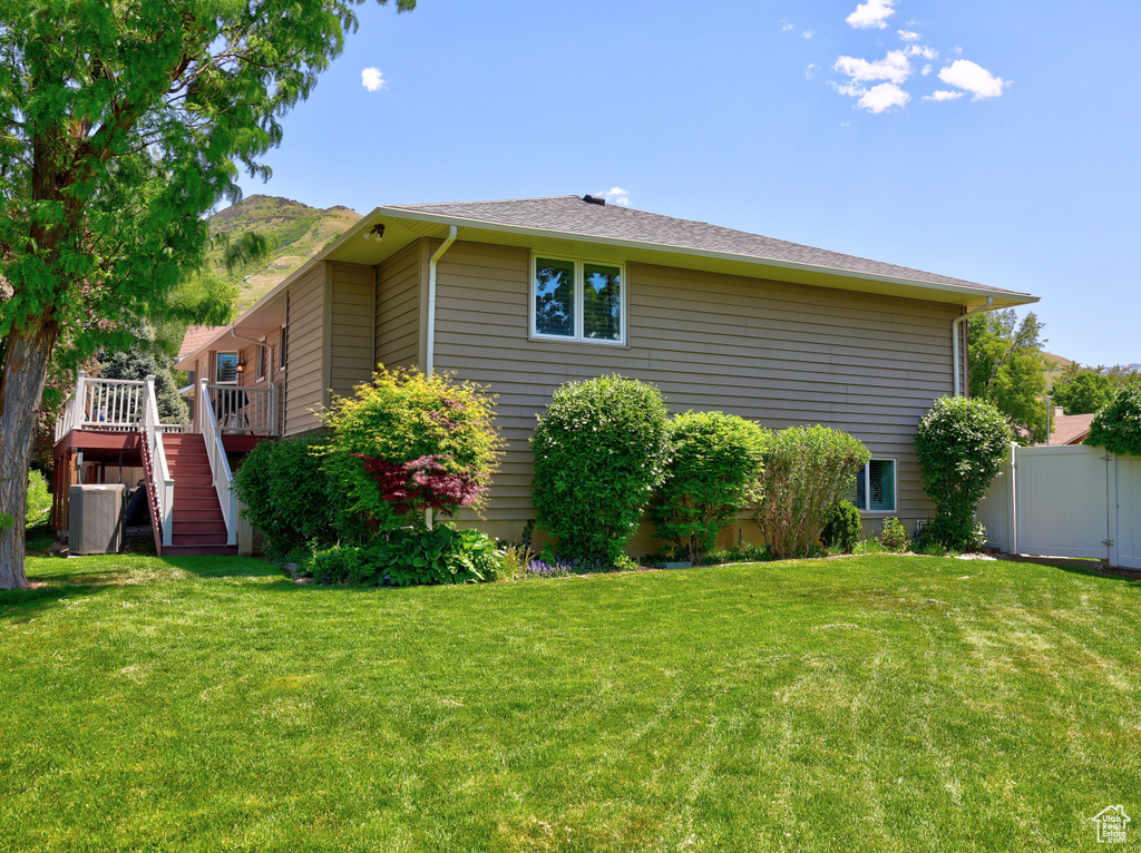 View of side of home with stairs and a wooden deck