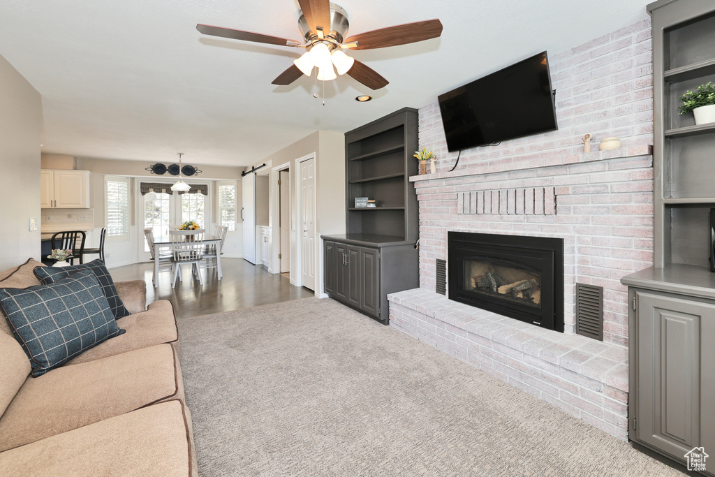 Living room featuring ceiling fan, a fireplace, and built in features
