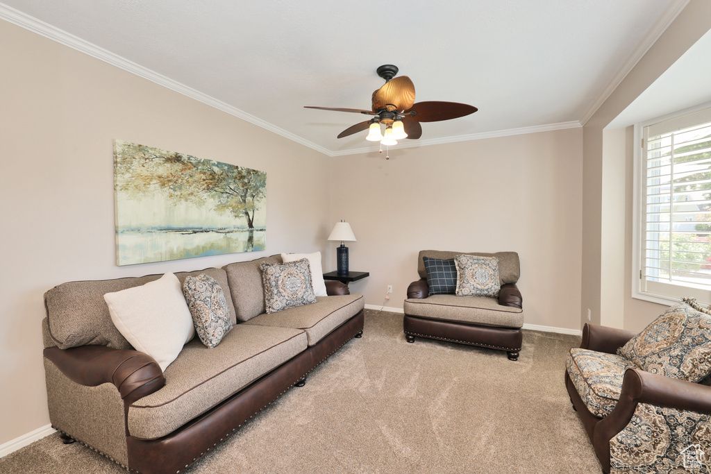 Living area featuring ornamental molding, carpet, baseboards, and a ceiling fan