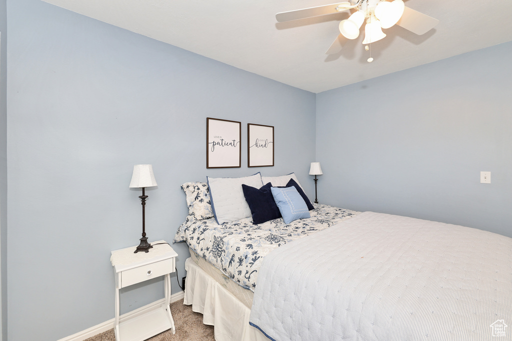 Carpeted bedroom featuring baseboards and ceiling fan
