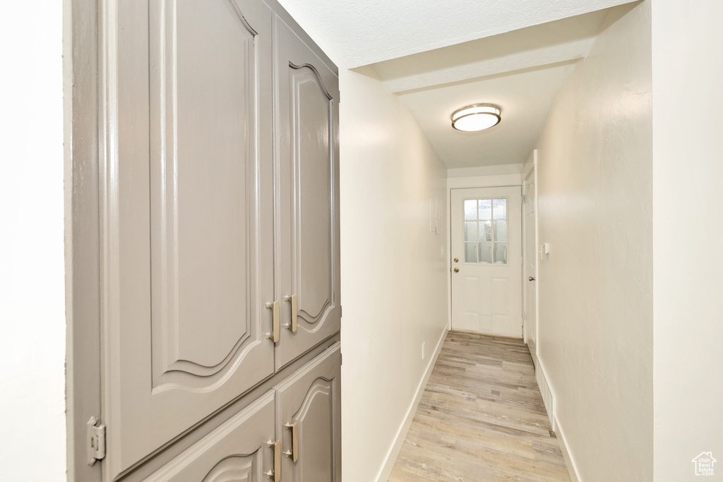 Hall with baseboards and light wood-type flooring
