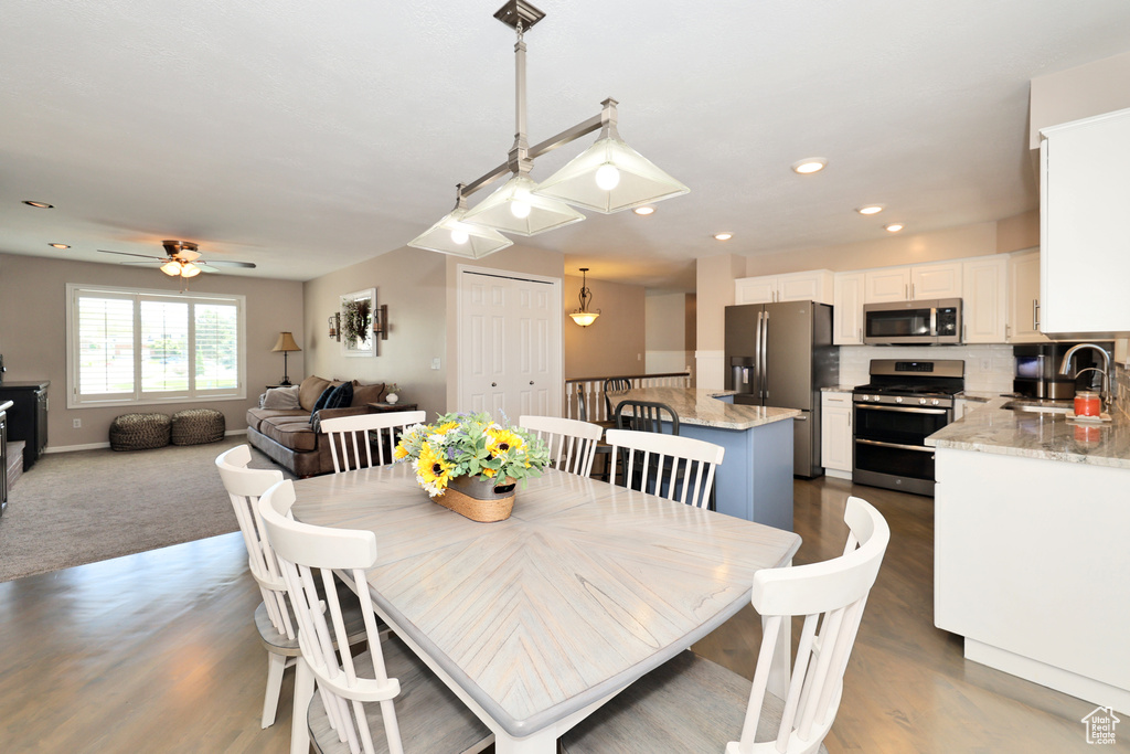 Dining space featuring ceiling fan, baseboards, wood finished floors, and recessed lighting