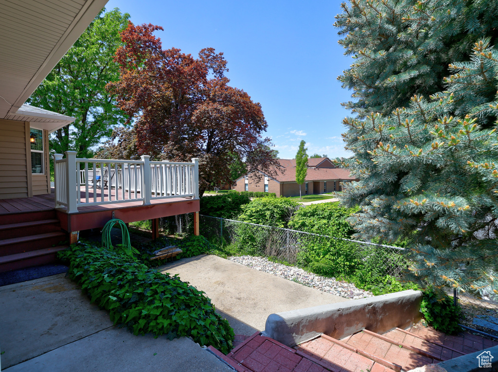 View of yard featuring a deck, a patio, and fence